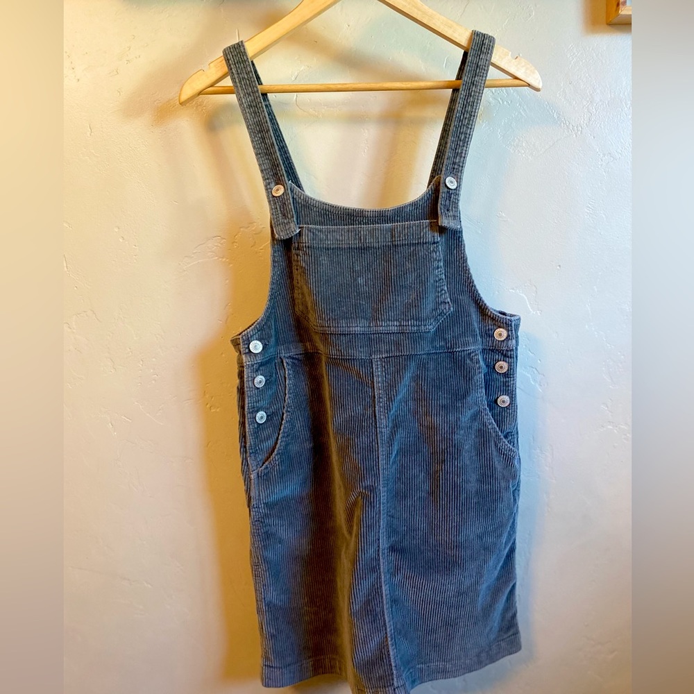 Sleeveless overall mini dress with a front and back pockets.